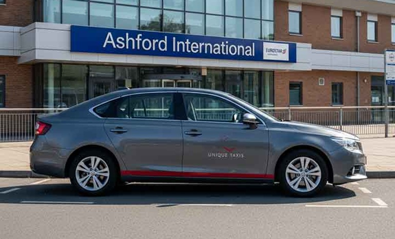 A modern Ashford taxi waiting outside Ashford International Station, offering reliable transfers across Kent by Unique Taxis.